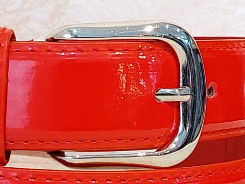 Női öv- Piros színű, lakhatású felülettel készült női öv, ezüstszínű fém csattal 33mm. 