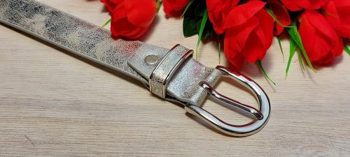 Női öv- Ezüst színű bőrhatású női öv ezüstszínű fém csattal, díszített bújtatóval 29mm.